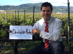 EPA Pacific Southwest Administrator Jared Blumenfeld holds a handmade sign that says #CleanWaterRules in a vineyard near the Napa River.