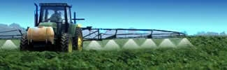 A tractor applying pesticides to farm crops