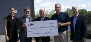 Check presentation from a Mystic River grant ceremony.