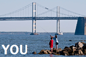 Photo for 'You': Two people fishing in a bay by a bridge.