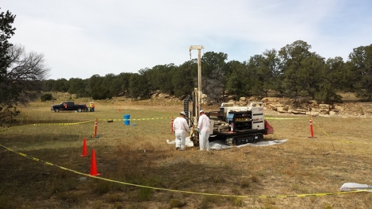 Workers in an open field working with sampling equipment.