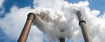 Photo of three smokestacks emitting smoke