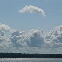 Photo of puffy clouds in sky above Salish Sea