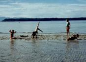 Vintage photo of children playing at the edge of the water.