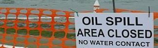 Picture of a sign that indicates that the area is closed due to an oil spill on the water.