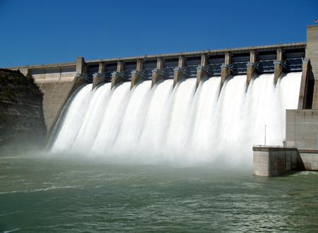 Water flowing over flood gates of a dam