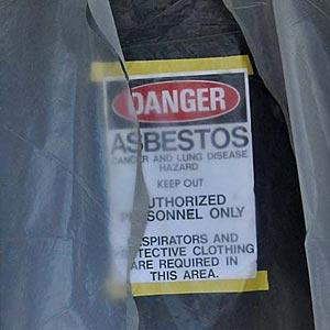 Sign in a doorway reads Danger: Asbestos
