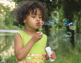 A picture of a little girl blowing bubbles