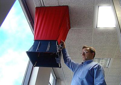 A picture of a man checking a flow hood