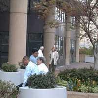 A picture of employees smoking on a sidewalk