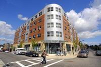 Modern-looking five story building on a street corner