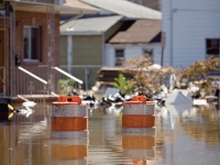 Photo: Floodwater approaches the tops of safety cones in a residential community