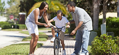 image of parents teaching children how to ride a bike