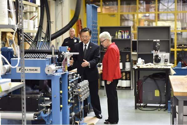 Administrator McCarthy looking at machinery in a factory.