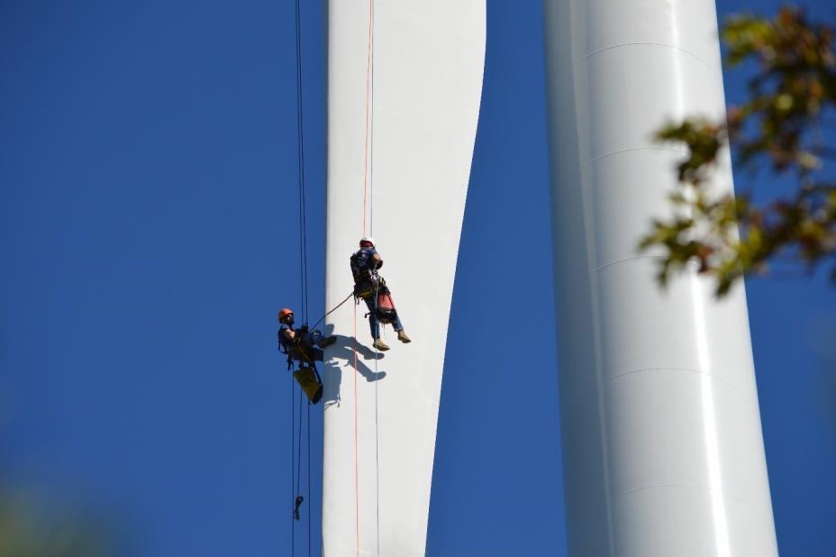 Air Force personnel inspecting the wind turbine blades