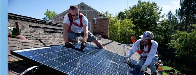 Dos hombres que trabajan en el techo de la instalación de paneles solares
