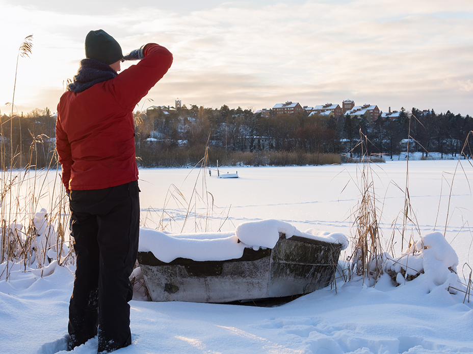 Photo of person standing by frozen lake