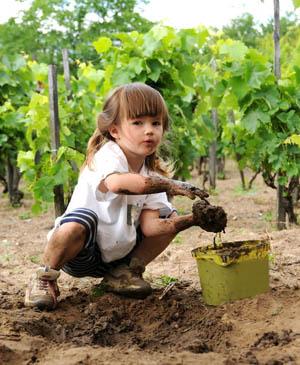 Little girl playing in the dirt in a garden