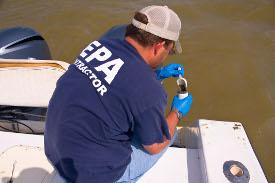 An EPA worker takes a water sample