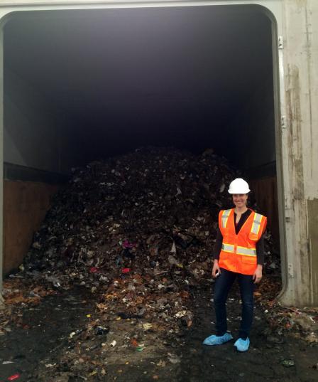 Amanda Hong standing in front of large food scraps pile