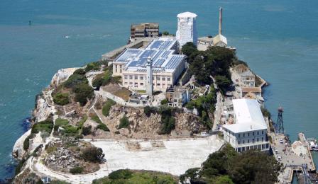 Aerial view of Alcatraz with solar panels on roof of main building clearyl visible, covering entire roof.