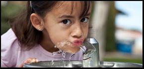 Closeup of girl drinking from water fountain