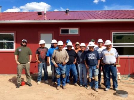 Workers standing in front of a  completed home.