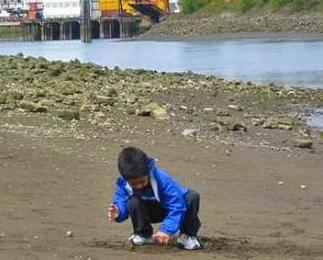 image of child playing on river sandbar