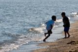 Photo of kids playing in water on a sandy beach