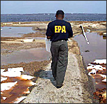 EPA inspector observing the toxic chemical cesspools left behind following Hurricane Katrina in Louisianna in 2005