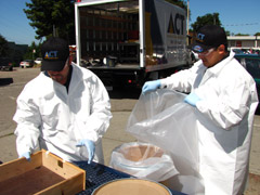Personnel in hazmat suits remove mercury-filled equipment from Oakland High School