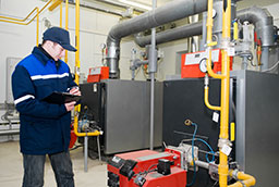 An inspector examines commerical water usage in a boiler room.