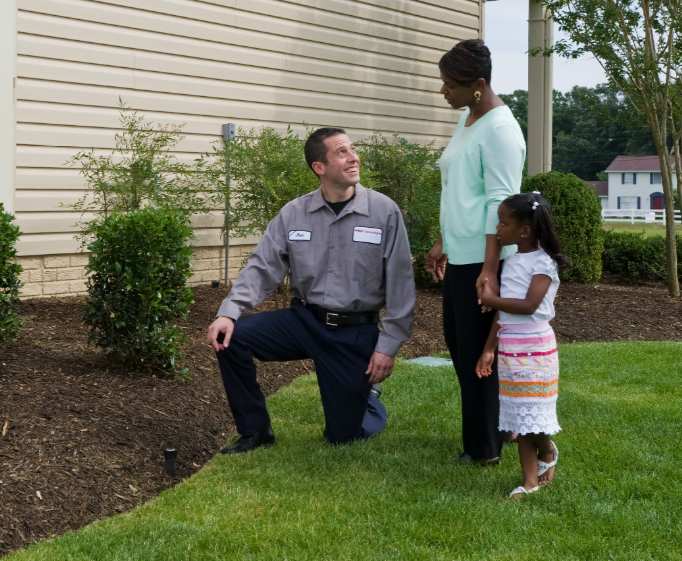 A professional irrigation specialist speaks with a family about the need for water-efficient landscaping.